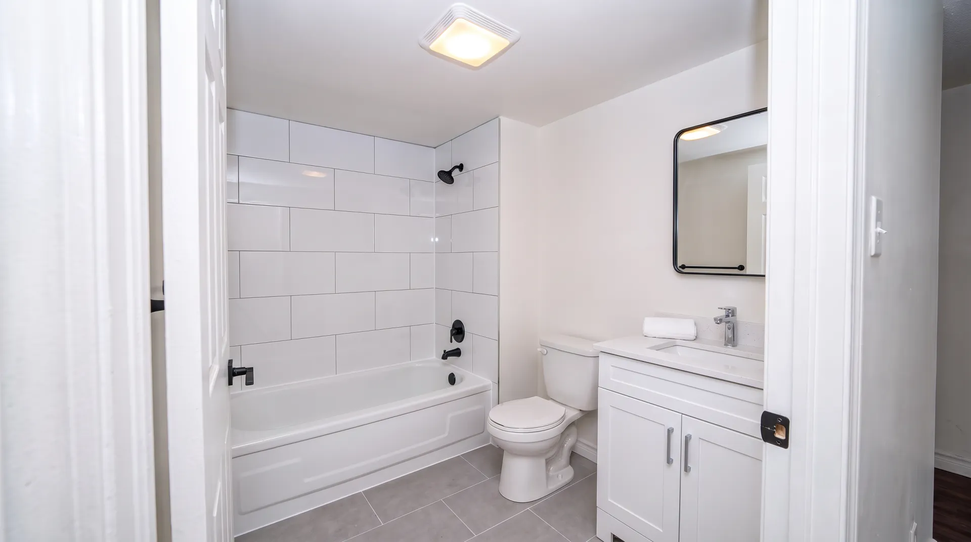 Illustration of the same bathroom finished with a new vanity, toilet, mirror and light